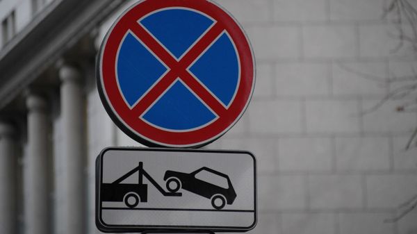 Дорожные знаки Остановка запрещена и Работает эвакуатор 