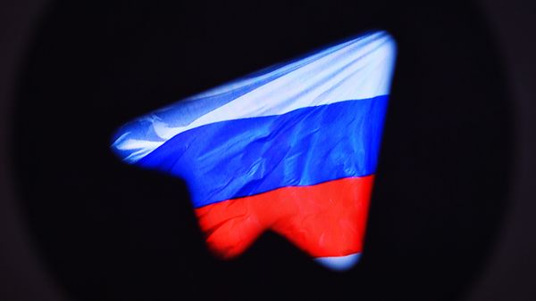 Логотип социальной сети Телеграм на фоне российского флага