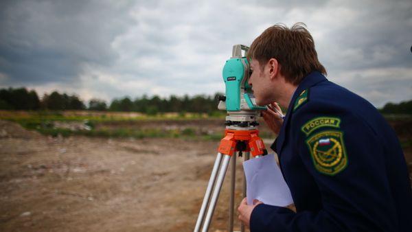 Сотрудник Управления Федеральной службы государственной регистрации, кадастра и картографии (Росреестр) по Московской области смотрит в нивелир Архивное фото