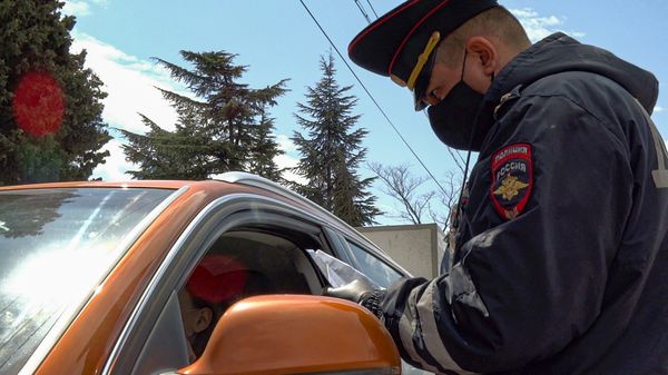 Сотрудник ГИБДД проверяет документы у водителя