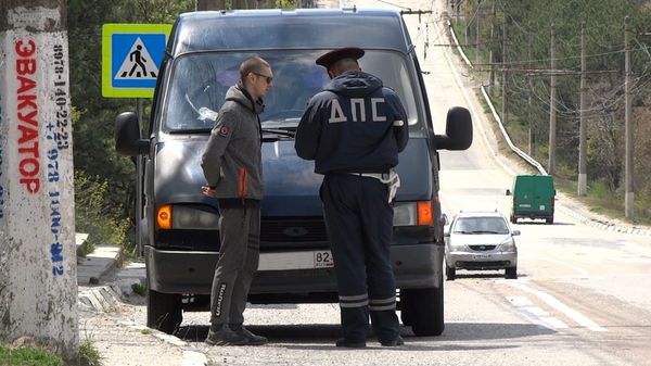 Сотрудник ГИБДД проверяет документы у водителя
