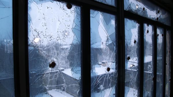 Следы от пуль на окне в одном из домов в ДНР