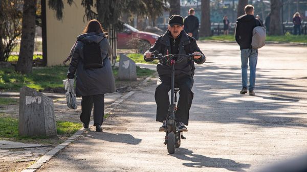 Мужчина на электросамокате в пешеходной зоне