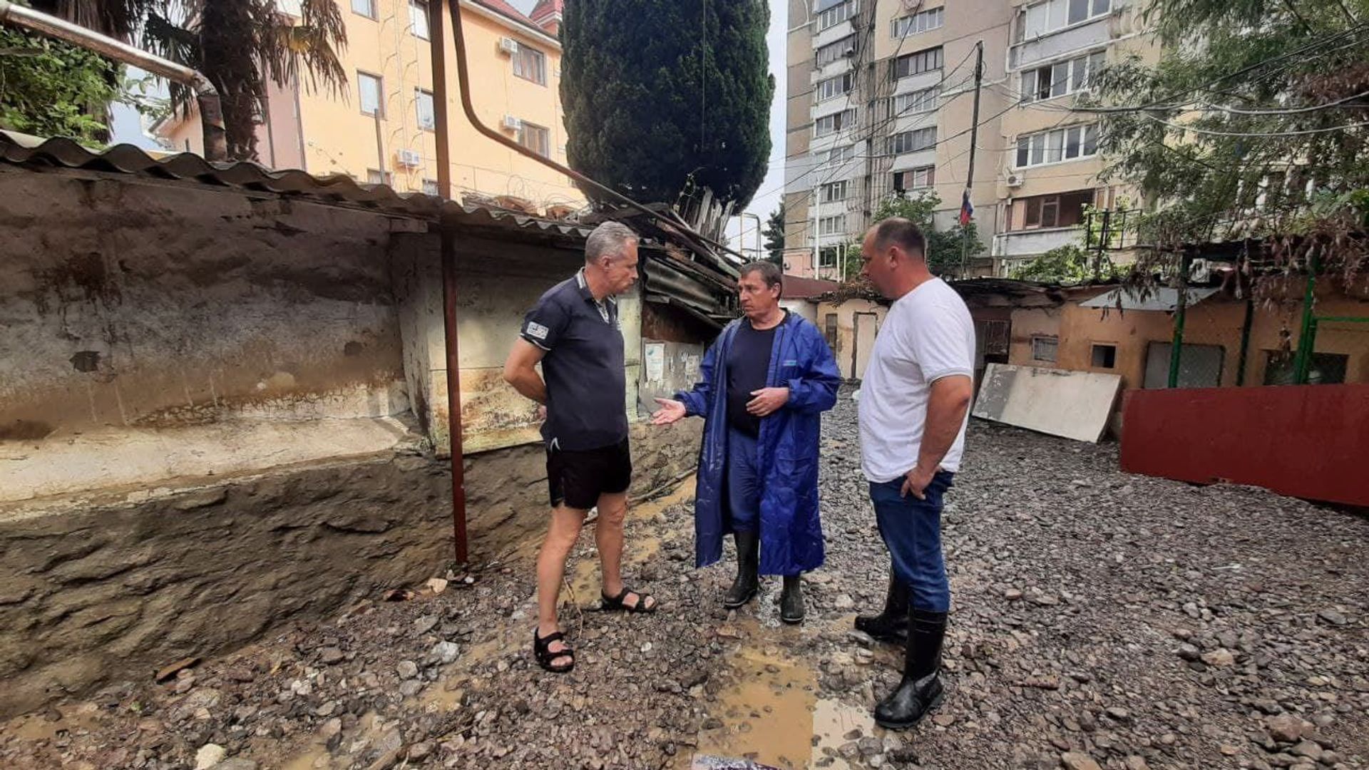 Крымский премьер Юрий Гоцанюк (в центре) и министр ЖКХ РК Сергей Донец объясняют местному жителю порядок компенсаций после наводнения. Ялта, 26 июня 2021 года - РИА Новости, 1920, 28.06.2021