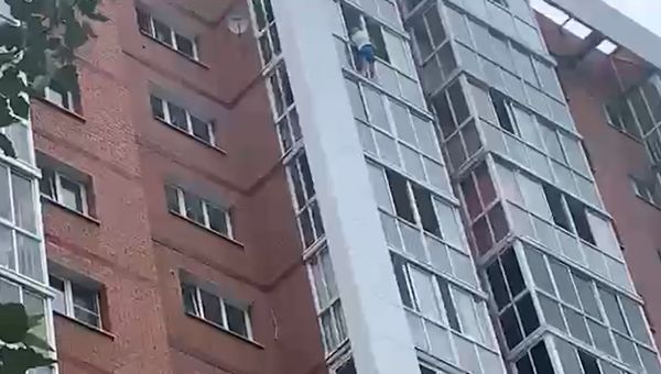Мужчина с ребенком на парапете балкона в Иркутске (копия)