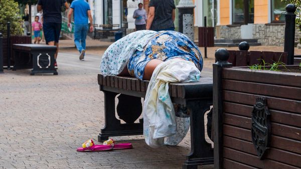 Женщина спит на скамейке