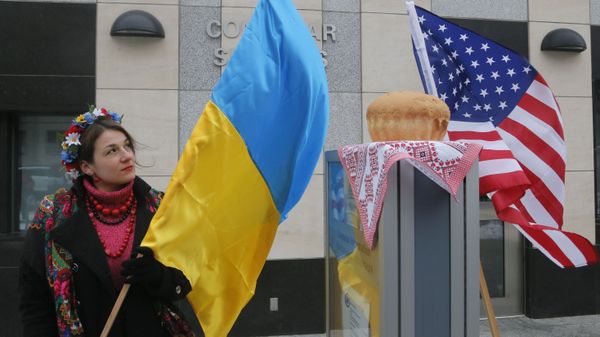 Девушка с украинским флагом у посольства США в Киеве 