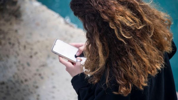 Девушка смотрит в мобильный телефон