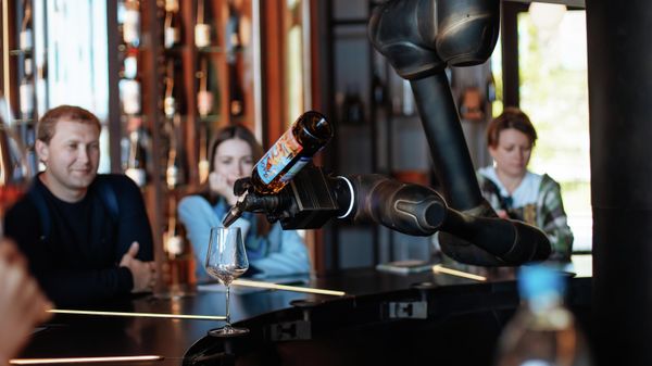 Робот наливает вино для посетителей ежегодного фестиваля WINEPARK Fest