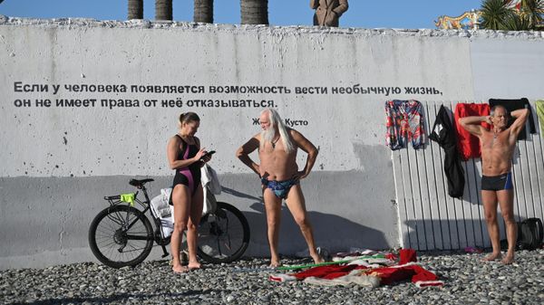 Отдыхающие на галечном пляже у Черного моря в Сочи