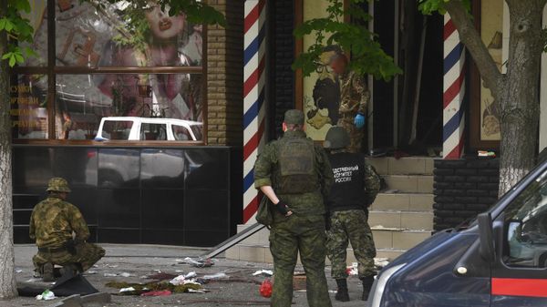 Сотрудники Следственного Комитета России и военные на месте взрыва возле барбершопа в Луганске