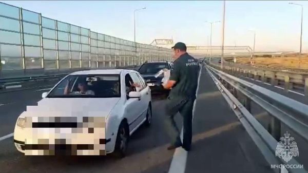 Сотрудники МЧС раздают воду автомобилистам, застрявшим в пробке перед Крымским мостом со стороны Краснодарского края