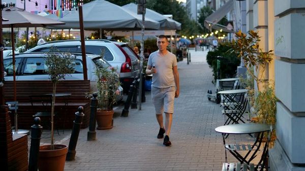 Евгений Куруч, 38-летний украинский офицер запаса, а ныне водитель такси, идет по улице в Варшаве, Польша, 31 июля 2023 года. 