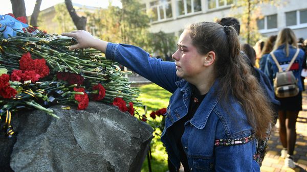 Люди возлагают цветы к мемориалу на территории Керченского политехнического колледжа в память о погибших при трагических событиях 17 октября 2018 года