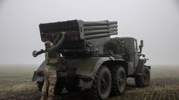 Украинский военный возле машины с РСЗО Град