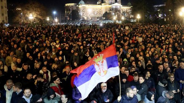 Протестующие собираются перед зданием городского совета Белграда во время демонстрации в Белграде 24 декабря 2023 года