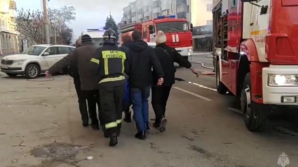 Сотрудники МЧС несут раненого во время атаки ВСУ на Белгород Сотрудники МЧС несут раненого во время атаки ВСУ на Белгород