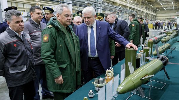Министр обороны РФ Сергей Шойгу (второй слева) осматривает образцы высокоточных боеприпасов и зенитных управляемых ракет