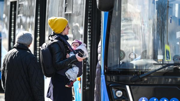 Женщина с ребенком перед автобусом
