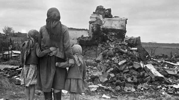 Жители села возле разрушенного немецко-фашистскими захватчиками дома