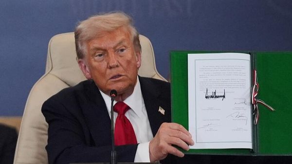 Президент Дональд Трамп держит подписанный документ во время саммита в поддержку прекращения более чем двухлетней войны Израиля и ХАМАС в секторе Газа 