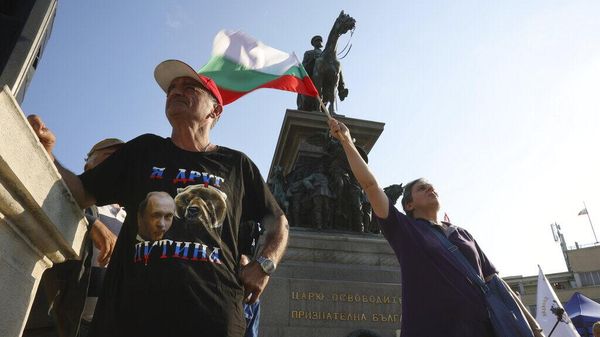 Антиправительственный демонстрант в футболке с фотографией Путина и плакатом на русском языке Я друг Путина во время антиправительственной демонстрации перед зданием болгарского парламента в Софии