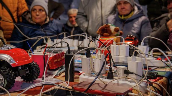 Люди заряжают свои телефоны в одной из обогреваемых палаток. Украина