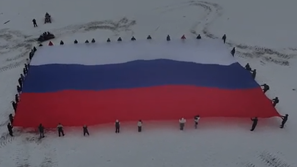 Жители КБР развернули флаг России на Эльбрусе