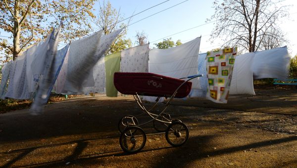 Прогулочная коляска на территории одного из  домов ребенка.