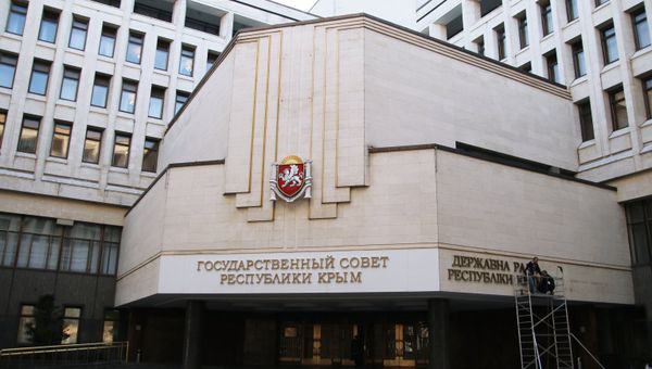 Рабочие крепят на фасад Государственного совета Республики Крым название парламента на украинском языке в городе Симферополе. Архивное фото