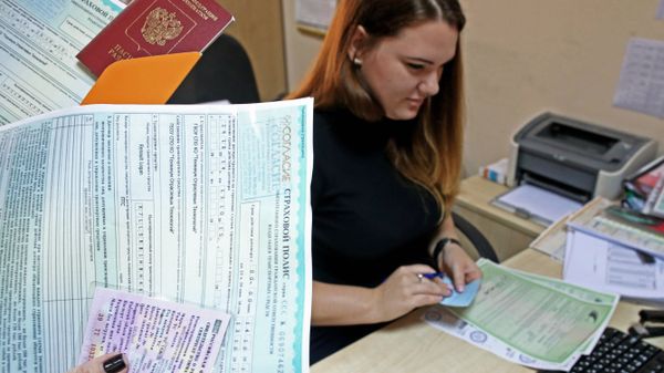 Оформление полиса ОСАГО в страховой компании. Архивное фото