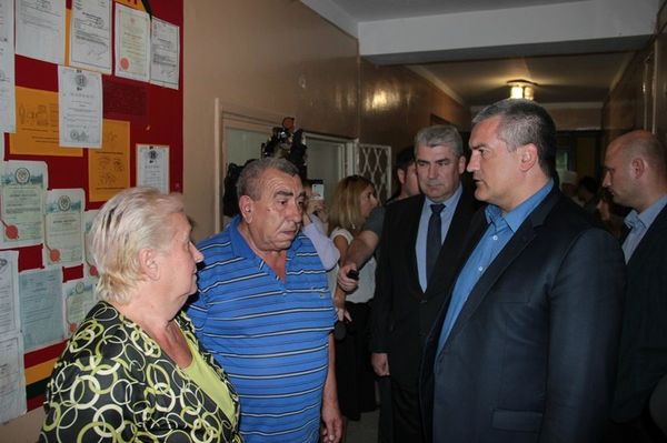 Родители (на фото слева) фельдшера скорой Владимира Слончака, раненого во время нападения злоумышленника на подстанцию в Симферополе, общаются с главой РК Сергеем Аксеновым