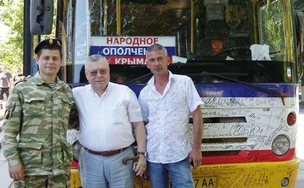 Водитель легендарного автобуса ополчения Андрей Ролик с председателем Общественной палаты Крыма Г. Иоффе и народным ополченцем около своего автобуса