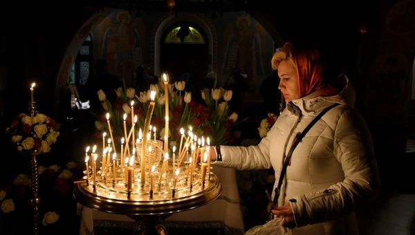 Женщина ставит свечку в Топловском Свято-Троице-Параскевиевском женском монастыре