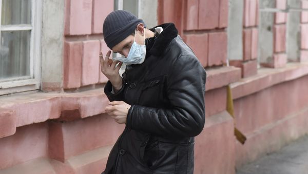 Молодой человек в защитной маске на улице Симферополя