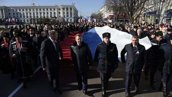 Торжественные мероприятия в Симферополе в честь второй годовщины референдума 2014 года. Начало шествия. Глава РК Сергей Аксенов, полпред президента в КФО Олег Белавенцев и председатель Госсовета РК Владимир Константинов несут российский флаг
