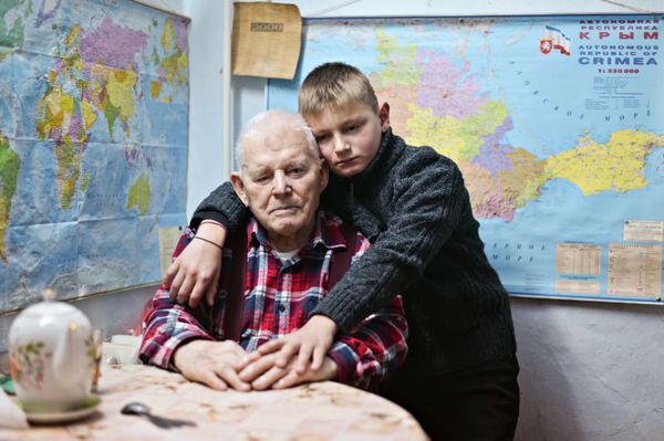 Ветеран Великой Отечественной войны Михаил Радченко у себя дома на кухне с правнуком Валерой в посёлке Аджимушкай, Керчь Ветеран Великой Отечественной войны Михаил Радченко у себя дома на кухне с правнуком Валерой в посёлке Аджимушкай, Керчь