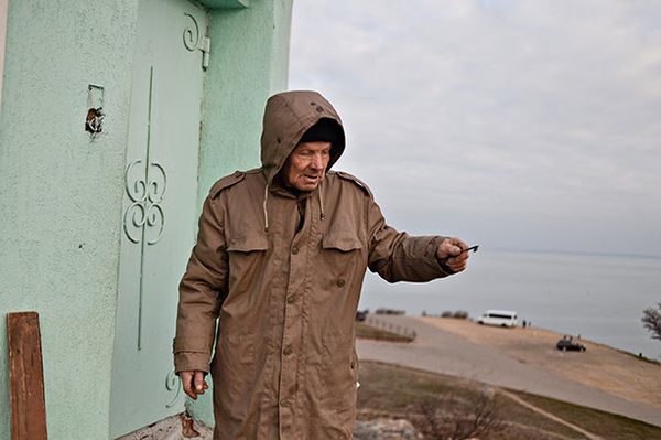 Главный хранитель Вечного огня на горе Митридат Владимир Терентьев рядом с входом в служебное помещение под факелом, Керчь Главный хранитель Вечного огня на горе Митридат Владимир Терентьев рядом с входом в служебное помещение под факелом, Керчь