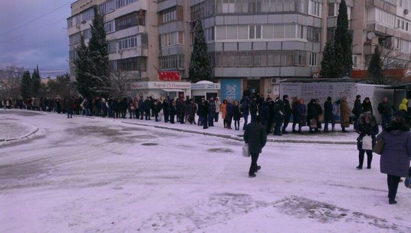 Жители Севастополя стоят в очереди в ожидании общественного транспорта