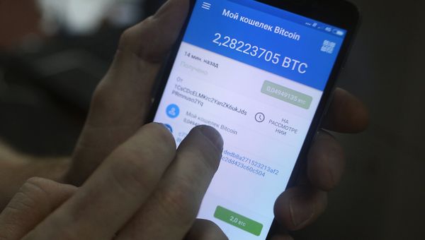 Демонстрация на смартфоне мобильного приложения для работы с криптовалютой биткоин Демонстрация на смартфоне мобильного приложения для работы с криптовалютой биткоин