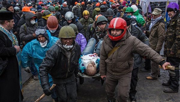 Сторонники оппозиции несут раненного во время столкновений с сотрудниками правопорядка на площади Независимости в Киеве Сторонники оппозиции несут раненного во время столкновений с сотрудниками правопорядка на площади Независимости в Киеве