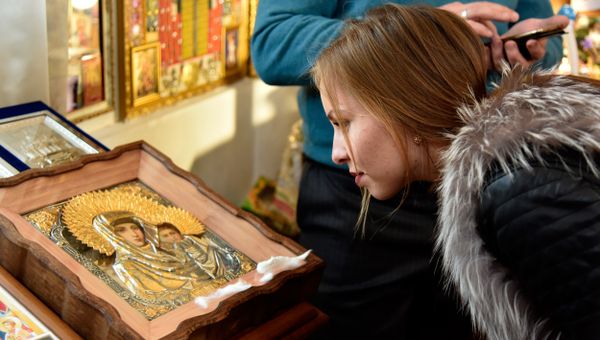 Посетительница часовни в честь святых царственных страстотерпцев государя Николая II и его семьи, расположенной возле прокуратуры Республики Крым