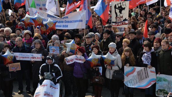 Участники митинга в честь третьей годовщины воссоединения Крыма с Россией на Корабельной набережной во Владивостоке
