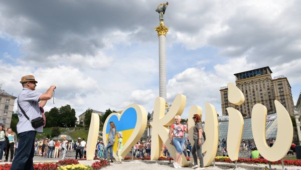 Люди фотографируются у инсталляции в Киеве во время празднования Дня города