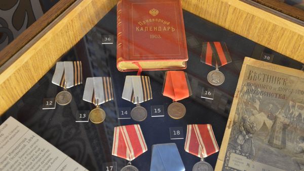 Золотые и серебряные нагрудные медали, придворный календарь императора. Экспонаты древлехранилища памяти семьи императора Николая II в Крестовоздвиженской дворцовой церкви в Ливадии Золотые и серебряные нагрудные медали, придворный календарь императора. Экспонаты древлехранилища памяти семьи императора Николая II в Крестовоздвиженской дворцовой церкви в Ливадии