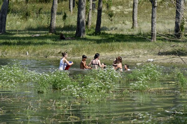 Люди купаются в Симферопольском водохранилище во время дневного зноя