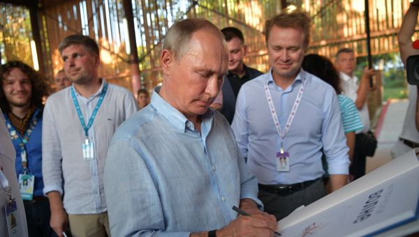 Президент РФ Владимир Путин знакомится с тематическими выставками творческих групп во время посещения ежегодного Всероссийского молодежного образовательного форума Таврида на Бакальской косе. 20 августа 2017