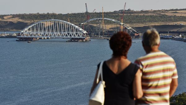 Люди смотрят на морскую операцию по транспортировке железнодорожной арки Крымского моста Люди смотрят на морскую операцию по транспортировке железнодорожной арки Крымского моста