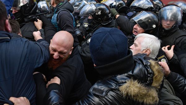 Участники вече у здания Верховной рады в Киеве и сотрудники правоохранительных органов во время драки у автомобиля с аппаратурой.