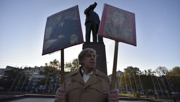 Участник шествия в честь 100-летия Великой Октябрьской социалистической революции с портретами Владимира Ленина и Иосифа Сталина на пл. им. Ленина в Симферополе